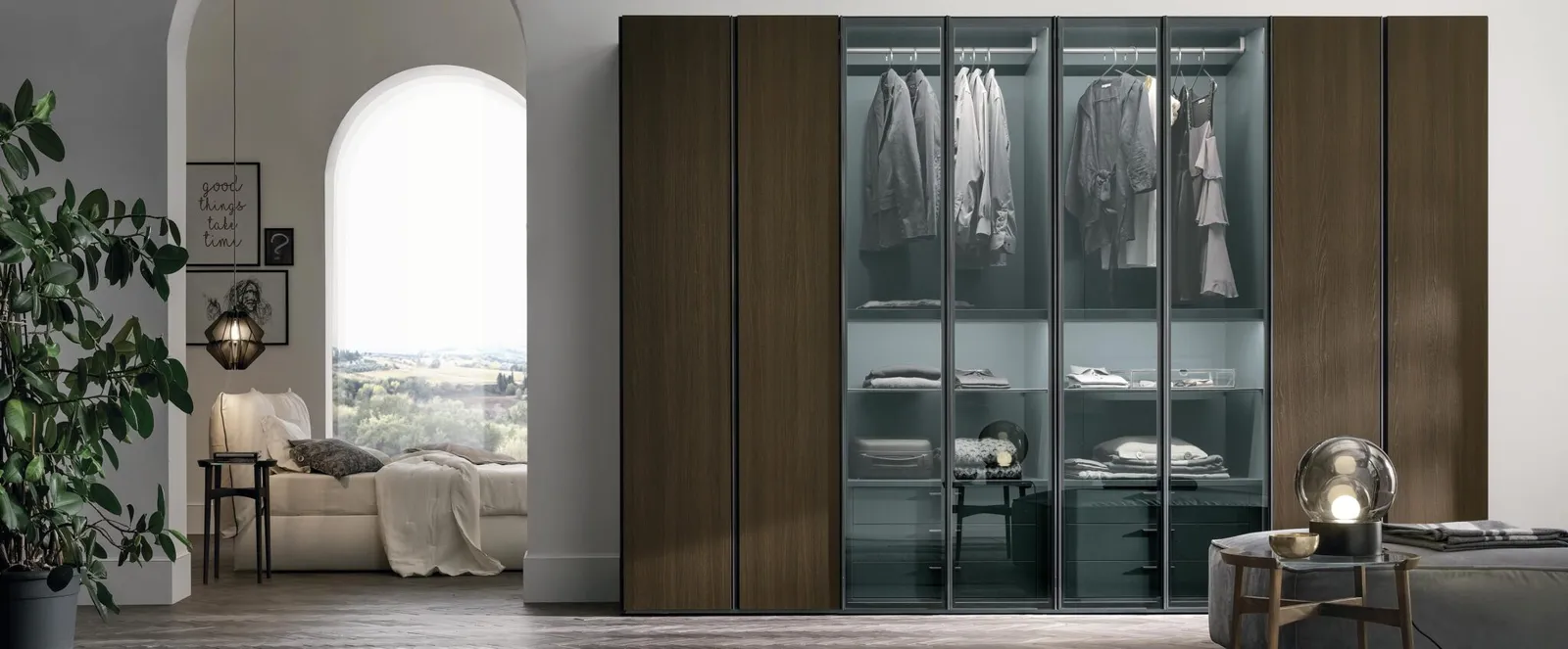 Bespoke wardrobe in wood and glass, hanging space visible in a bright bedroom