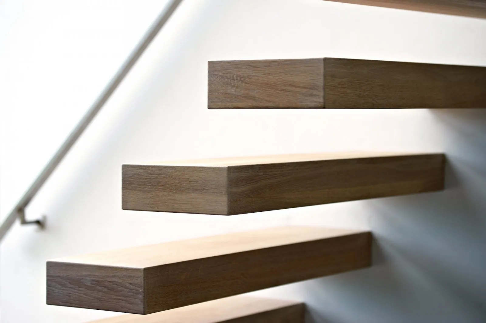 Détail d'un garde-corps d'escalier en acier mat et main courante bois